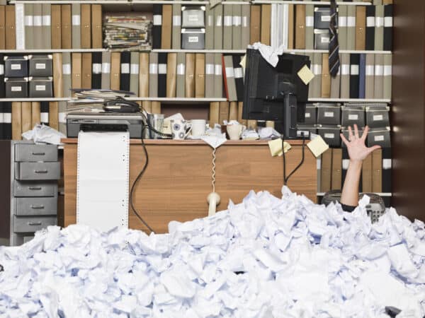 Mail2Fax. Faxe per E-Mail versenden. Büro mit Papiermüllbergen